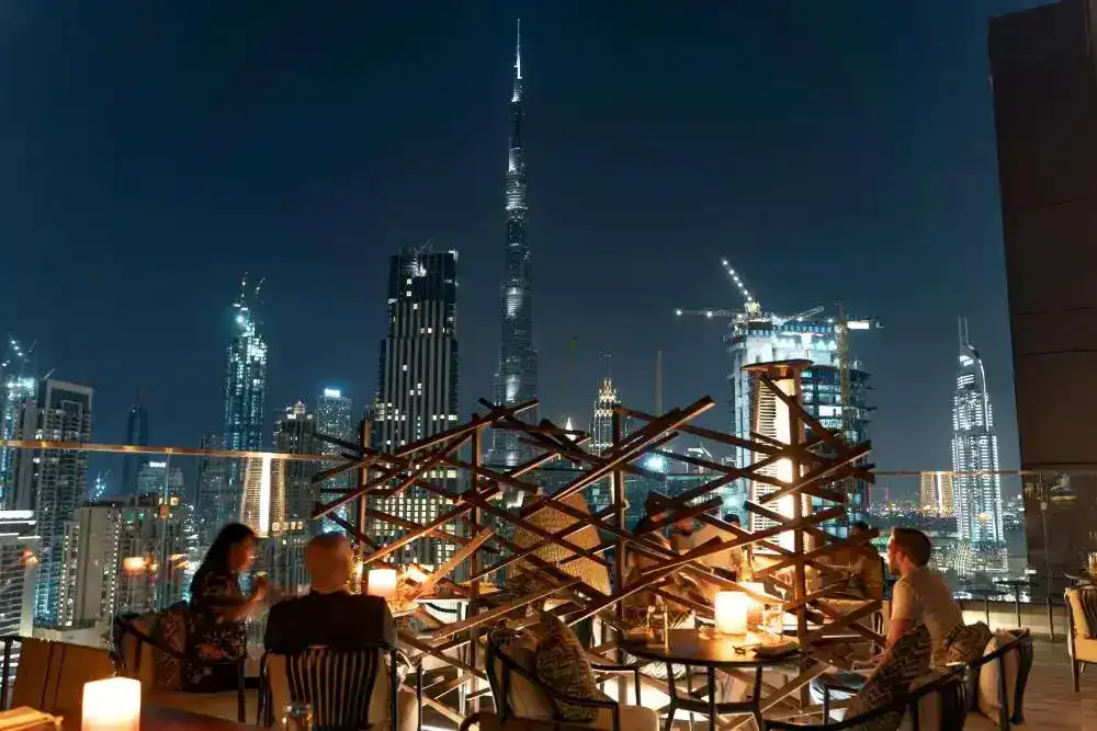 Rooftop bar at night with a view of Burj Khalifa.