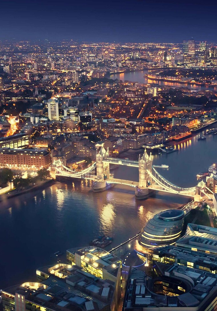 Illuminated Tower Bridge and London city skyline at night